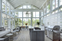 a screened in back porch with a outdoor kitchen